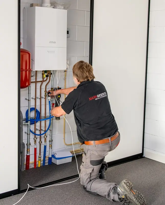 Medewerker van Mark Geerts Installatiewerken uit Baarle-Nassau doet onderhoud aan een cv ketel