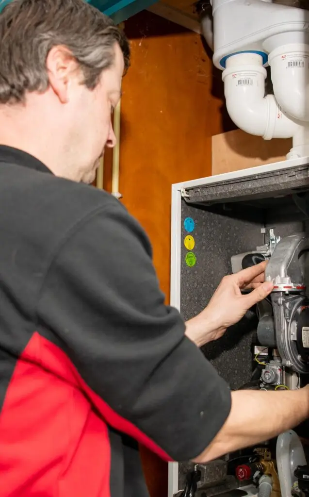 Een gecertificeerde onderhoudsmonteur van Mark Geerts Installatiewerken pleegt onderhoud aan een cv ketel